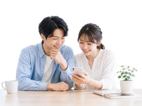 スマートフォンを見ながら住まい探しを相談する夫婦